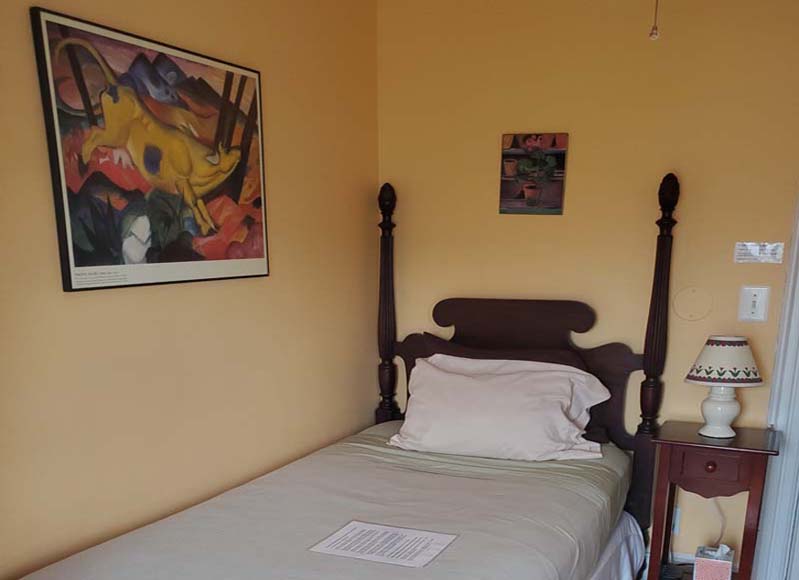 thumbnail: twin bed with posted headboard and large fanciful painting of a cow