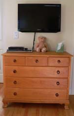 maple chest of drawers with TV on wall