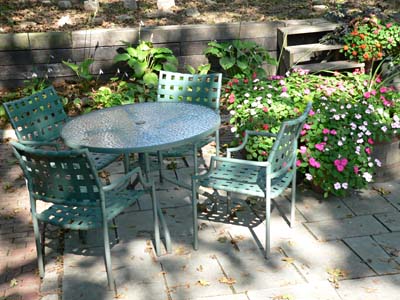 patio table and chairs with garden plants